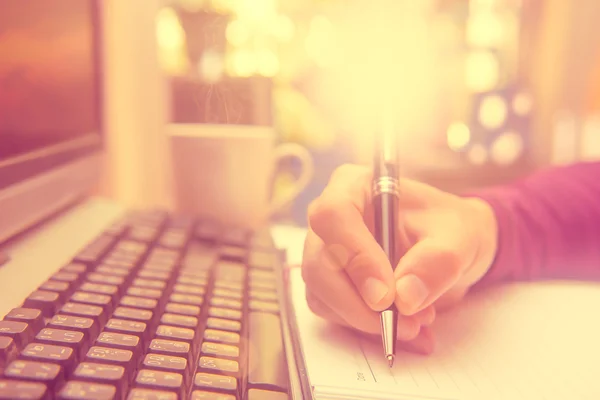 Yazmak üstünde belgili tanımlık defter bir kalem tutan adam el.