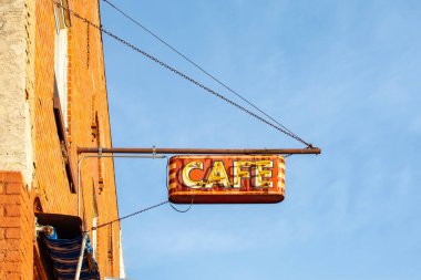 Neon ışıklı klasik asılı metal kafe tabelası.