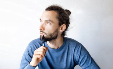 Kalemli sakallı genç adam fikirleri düşünüyor, not defterine not alıyor. Serbest çalışan, müteahhit, evde çalışan ya da okuyan bir öğrenci. Bir insan yeni yıl için bir dilek listesi oluşturur..