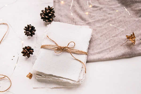 Estilo Hygge flat lay. Lista de desejos de Natal. Papel feito à mão amarrado com fio artesanal. envelope carta, cones de pinho, fio artesanal. Foco seletivo — Fotografia de Stock