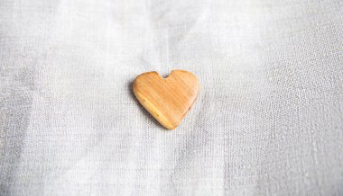 Keten kumaş arka planında tahta kalp. Sevgililer Günü, doğal dokular.