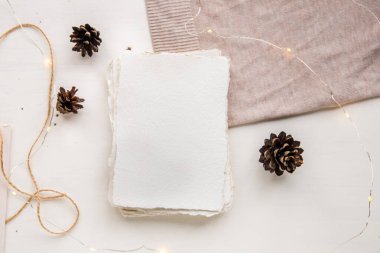 Hygge tarzı düz yatıyordu. Noel dilek listesi. El yapımı kağıt, el işi iplikle bağlanmış. Zarf, kozalak, el işi iplik..