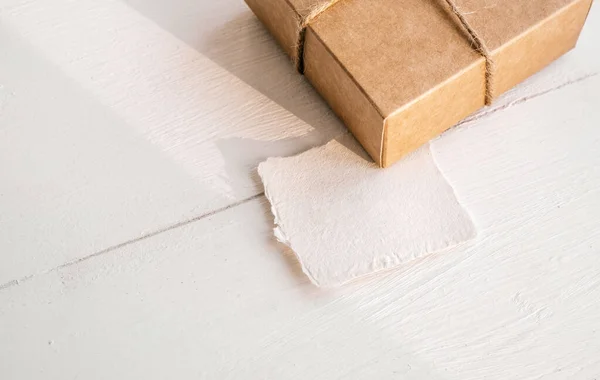 Zéró hulladék jelenlegi doboz koncepció. Kézműves ajándék doboz papír mock up megjegyzést fehér fa háttér. — Stock Fotó