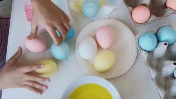 Les enfants jouent avec des œufs colorés. Joyeux Pâques décoration close up, vue de dessus, 4 K — Video