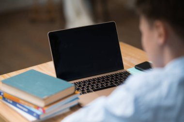 Çocuklar evden öğreniyor. Karantina sırasında uzak okul, online eğitim çocuğu. Laptop ve tablet bilgisayarlı üniversite öğrencisi.