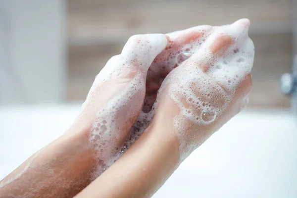 Mujer caucásica usar jabón y lavarse las manos bajo el grifo de agua. Concepto de higiene detalle de la mano. — Foto de Stock