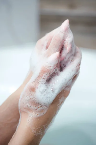 Mujer caucásica usar jabón y lavarse las manos bajo el grifo de agua. Concepto de higiene detalle de la mano. — Foto de Stock