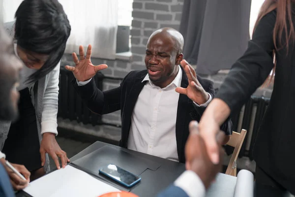 Um homem afro-americano emocional está preocupado com o resultado de um acordo com um parceiro. Empresário se alegra com a celebração de um contrato — Fotografia de Stock