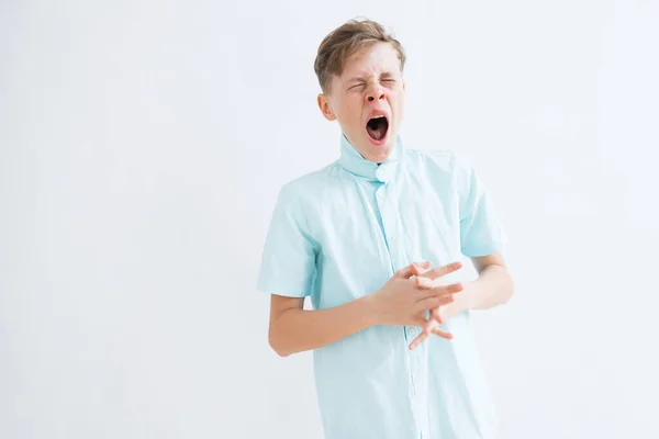 Um tiro médio de um adolescente cansado bocejando em um fundo branco — Fotografia de Stock