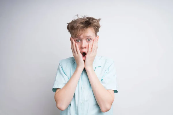 Um menino caucasiano surpreso em um fundo branco — Fotografia de Stock