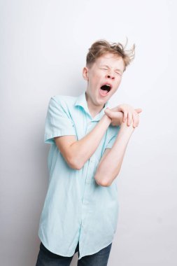 Beyaz arka planda esneyen yorgun bir gencin orta pozu.