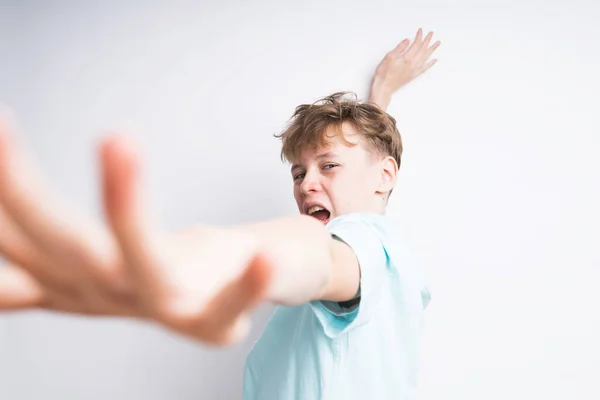 Um menino europeu bonito em uma camisa de pólo azul está dançando e cantando — Fotografia de Stock