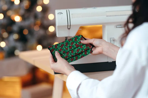 Close-up de uma máscara de Natal médica DIY. Máscara protetora com impressão de Ano Novo em mãos de mulher — Fotografia de Stock