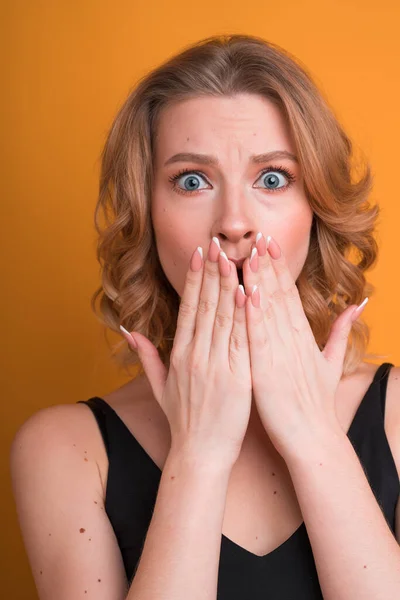 Blond choqué fille américaine couvrant sa bouche avec ses mains avec une manucure naturelle. Sentiments et émotions concept — Photo