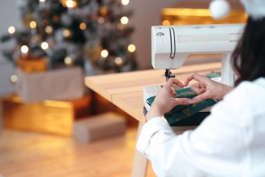 Bir atölye için Noel reklamı. Yüzünde kalp işareti olan bir kız, arka planında hediyeler olan bir Noel ağacı.