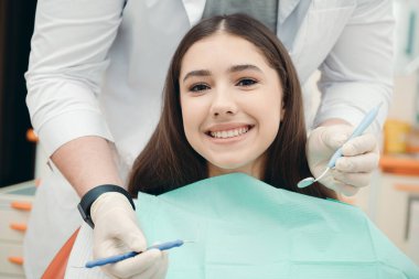 Muayene sırasında dişçinin ofisinde bir esmerin portresi. Sağlıklı dişler