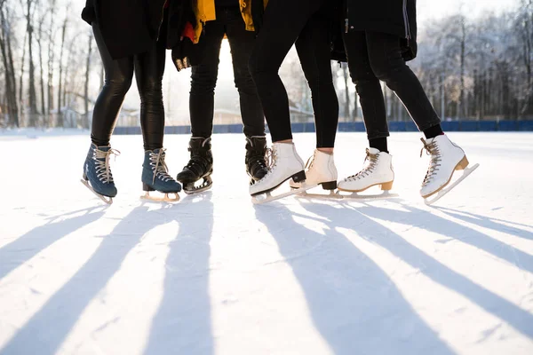 Ноги в чорних джинсах носять ковзани з тіні на снігу — стокове фото