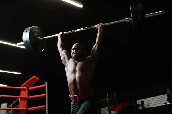 Ağırsıklet adam halterli antrenman yapıyor. Vücut geliştirme antrenörü spor salonunda ağırlık kaldırıyor, yarışmaya hazırlanıyor. — Stok fotoğraf