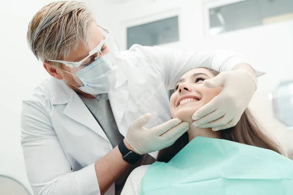 Tandarts controleert de kwaliteit van de tanden van een patiënt in een tandartsstoel — Stockfoto