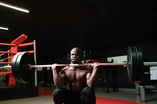 Treinador de powerlifting masculino fazendo agachamentos de barra. Homem musculoso observando seu corpo no ginásio — Fotografia de Stock