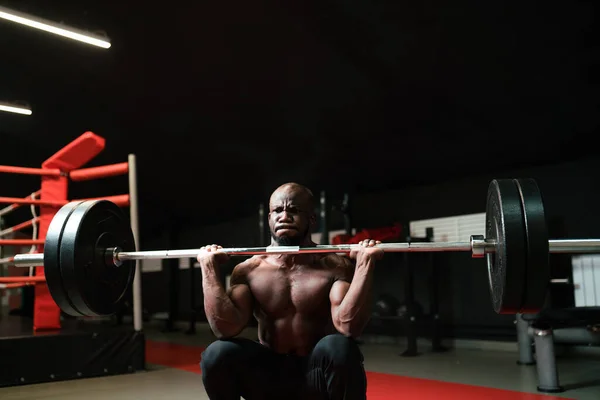 Halter kaldıran erkek antrenör. Spor salonunda kaslı bir adam vücudunu izliyor. — Stok fotoğraf