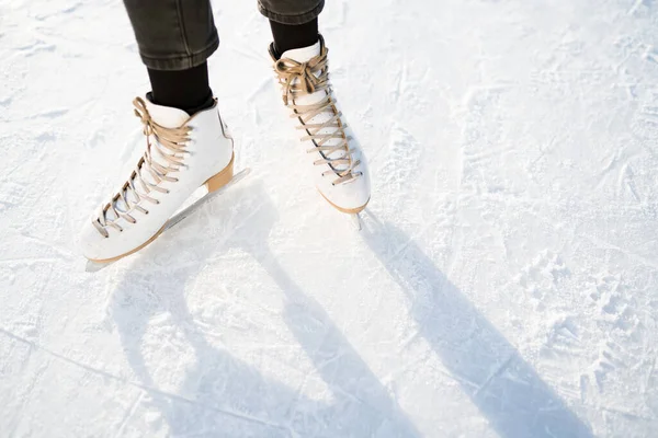 Photo of female legs in white skates that skate on ice. Winter weekend concept — Stock Photo, Image