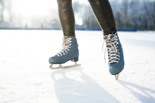 Foto de patins azuis com laço branco no fundo do brilho do sol no inverno — Fotografia de Stock