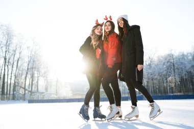 Geyik boynuzu şeklinde ceketli ve bantlı güzel kız arkadaşlar kışın kayıyorlar.