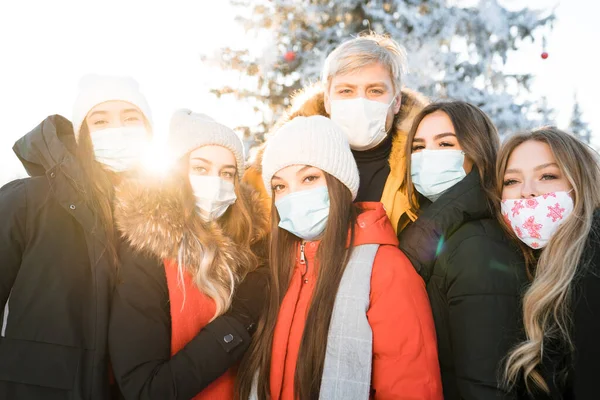 Una foto de grupo de amigos en ropa de invierno y máscaras especiales en la calle. Caminar durante una pandemia —  Fotos de Stock