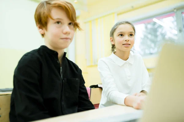 Dziewczyna w białej koszuli i chłopiec w czarnym swetrze studiują online za pomocą komputera — Zdjęcie stockowe