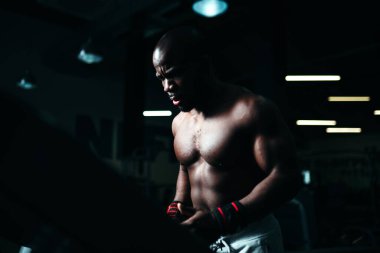 Spor salonunda atletik vücutlu bir adam koşu bandında koşuyor. Spor ve sağlık