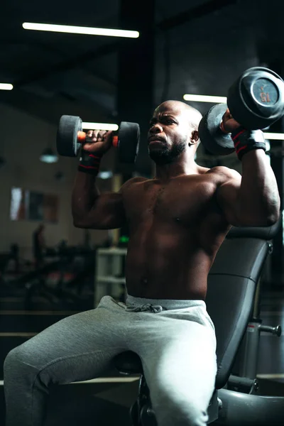 Afrikalı Amerikalı adam spor salonunda kol kaslarını geliştirmek için güç çalışması yapıyor. — Stok fotoğraf