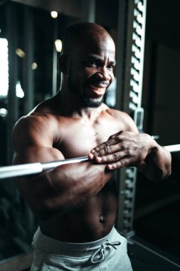 Eşofmanlı çıplak vücutlu kaslı bir adam spor salonunda egzersiz yapıyor. Sağlıklı yaşam tarzı