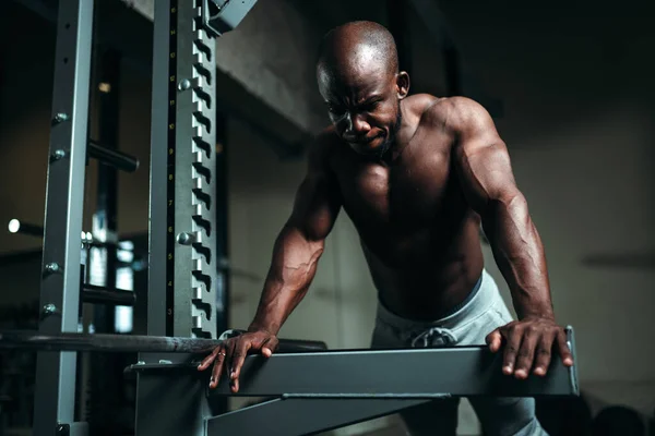 운동을 하는 남자는 특별 한 근육 강화 기계를 사용 해서 운동을 합니다 — 스톡 사진