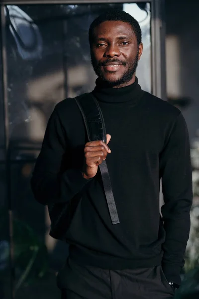 Μαθητής με μαύρο ζιβάγκο με σακίδιο στην πλάτη χαμογελώντας στην κάμερα. — Φωτογραφία Αρχείου