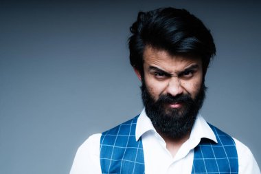 Koyu bir arka plana karşı duran bir adam öfke ve asabiyet gösterir. İnsan duyguları