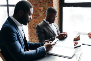 Büyük bir şirketteki erkek yöneticiler iş yerinde oturup akıllı bir telefonla oynuyorlar. Çalışanların iş yerinde dikkatleri dağılır. Telefon bağımlılığı kavramı