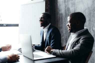 Afrikalı Amerikalı ofis çalışanları bilgisayar başında çalışır ve ofisteki iş arkadaşlarıyla iletişim kurarlar.