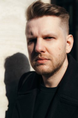 Sarışın ve sakallı, güneşten kırışık genç ve çekici bir adamın portresi.