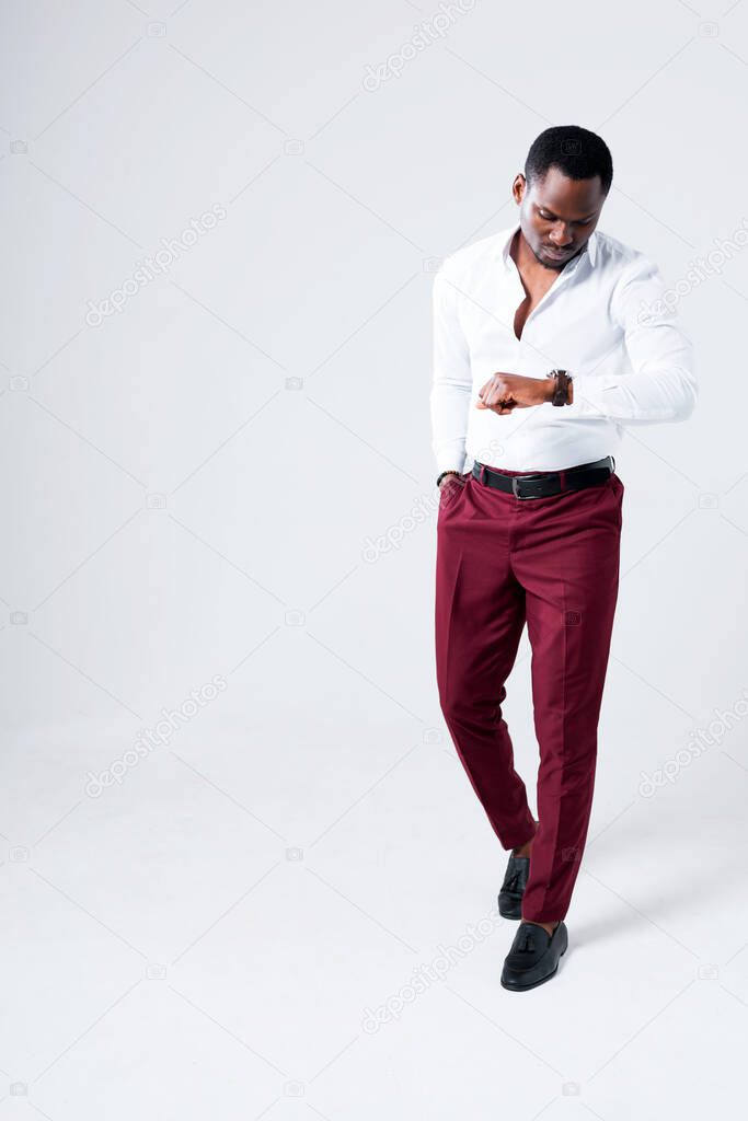 Handsome african american man in white shirt going to work looking at wristwatch