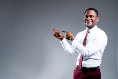 Neşeli Afro-Amerikalı adam geniş bir gülümseme sergiliyor ve elleriyle indirimden zevk alıyor.