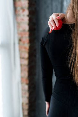 Arkadan bak. Kız, dayanıklılık eğitiminden sonra masaj topuyla boyun omurgasına masaj yapıyor..