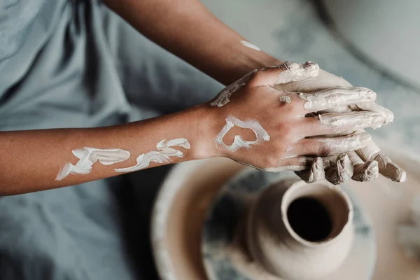 Mains féminines en argile avec un dessin d'un cœur dans un atelier de poterie. Concept publicitaire — Photo