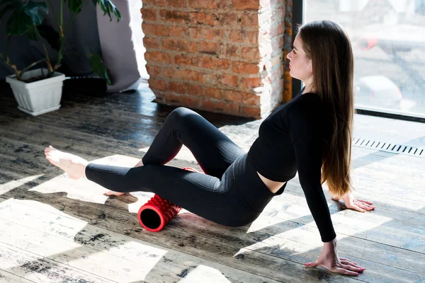 Vacker flicka är engagerad i gymmet gör övningar på benen med hjälp av fascia — Stockfoto