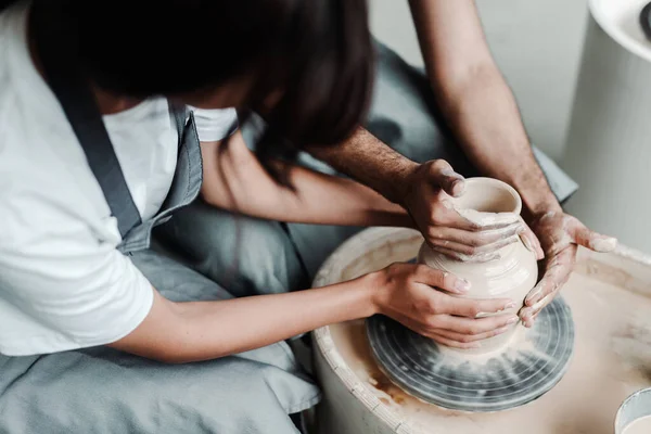 Modélisation d'un pot sur une roue de potiers. Les mains masculines et féminines se rapprochent. Une date dans un atelier de passe-temps — Photo