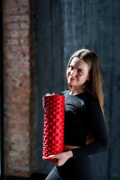 Menina bonita feliz em uniforme esportivo segurando fáscia em suas mãos e sorrindo olhando para a câmera — Fotografia de Stock