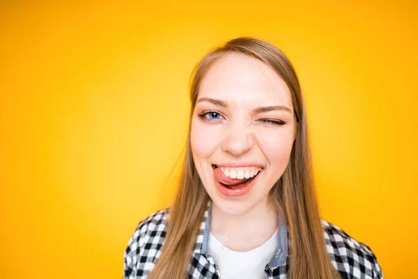 Vrolijk schattig meisje rommelen en lachen tonen tong en kijken naar de camera — Stockfoto