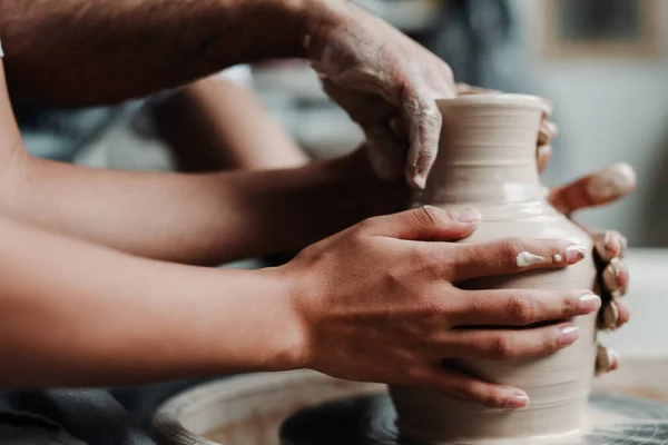 Ferme la photo. Les mains d'un homme font un vase d'argile dans un atelier d'argile à une classe de maître — Photo