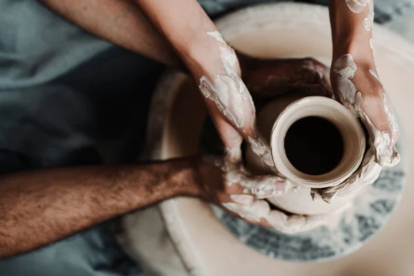 Photo d'en haut. Les mains d'un homme et d'une femme fabriquent un vase en argile sur une machine à l'aide d'un appareil. Concept de rencontre — Photo