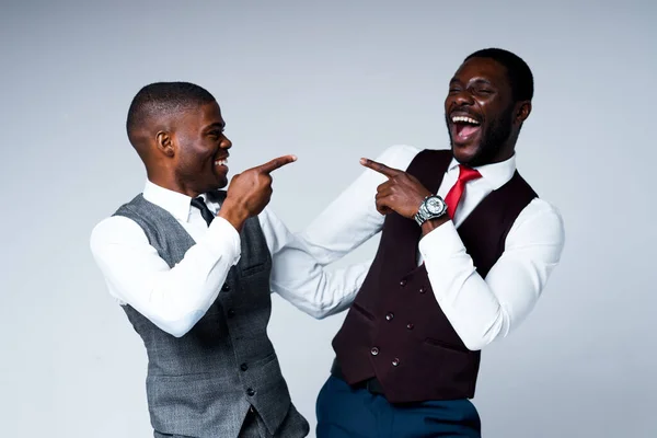 Dwóch szczęśliwych afrykańskich biznesmenów uśmiecha się i wytyka sobie palcami — Zdjęcie stockowe